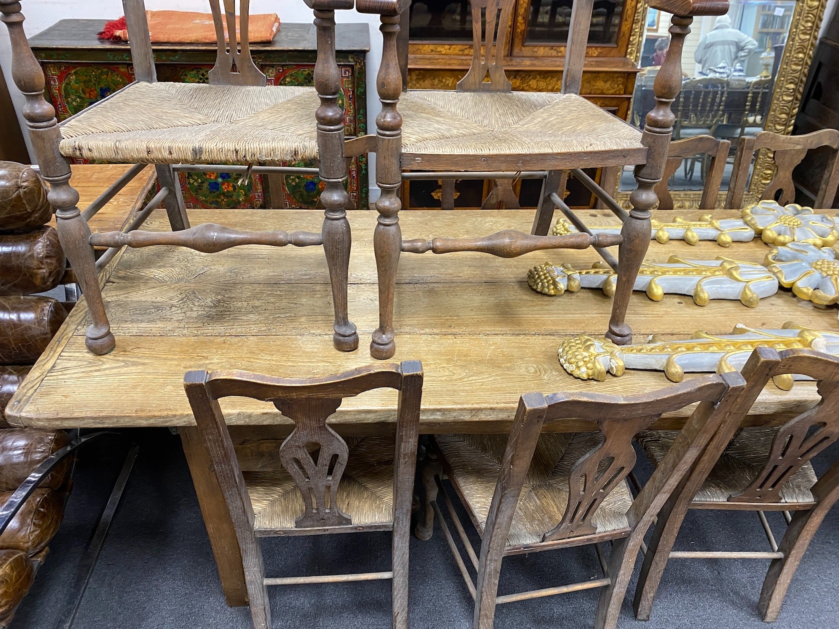 A 19th century elm plank topped kitchen dining table, on a beech underframe, the top, length 275cm, width 92cm, height 76cm, together with a set of ten oak and ask rush seated dining chairs (2 arm, 8 single)